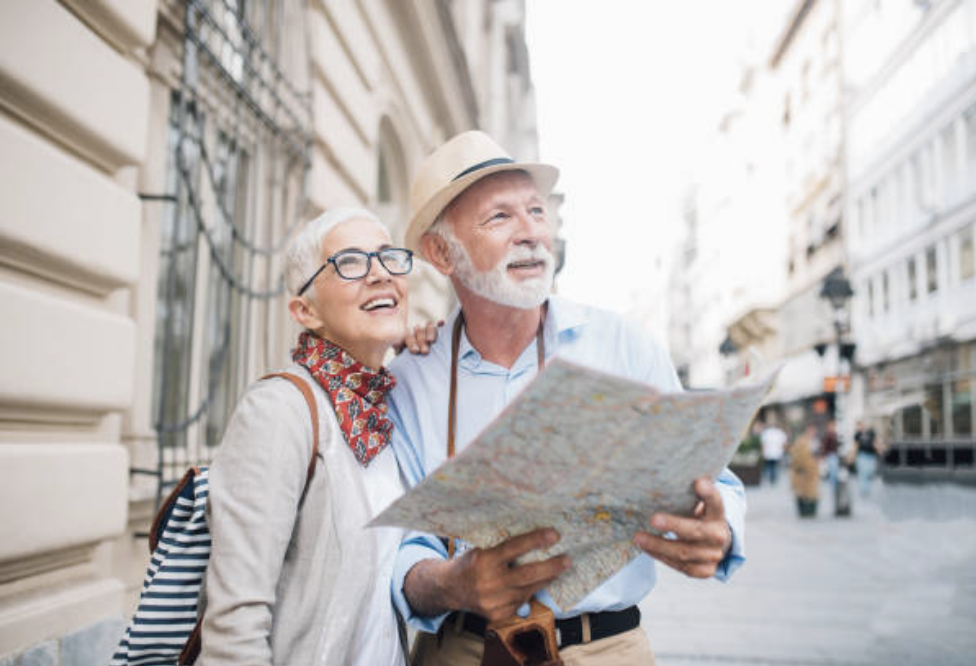 A retired couple reading a map while on vacation in a new city.