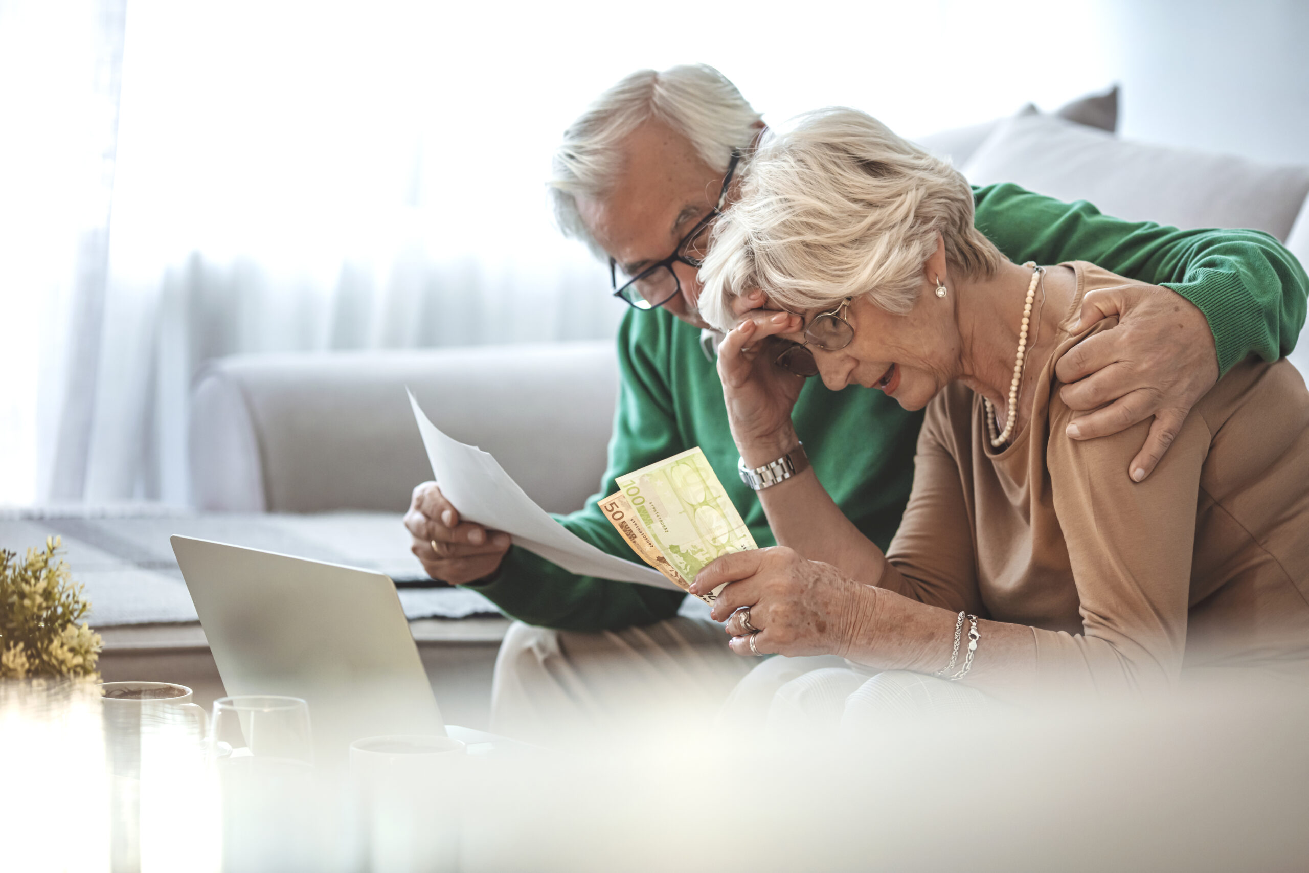 Senior couple at home with many bills. Worried Mature Couple Checking Finances And Going Through Bills Together. Shot of a senior couple working on their finances using a laptop.